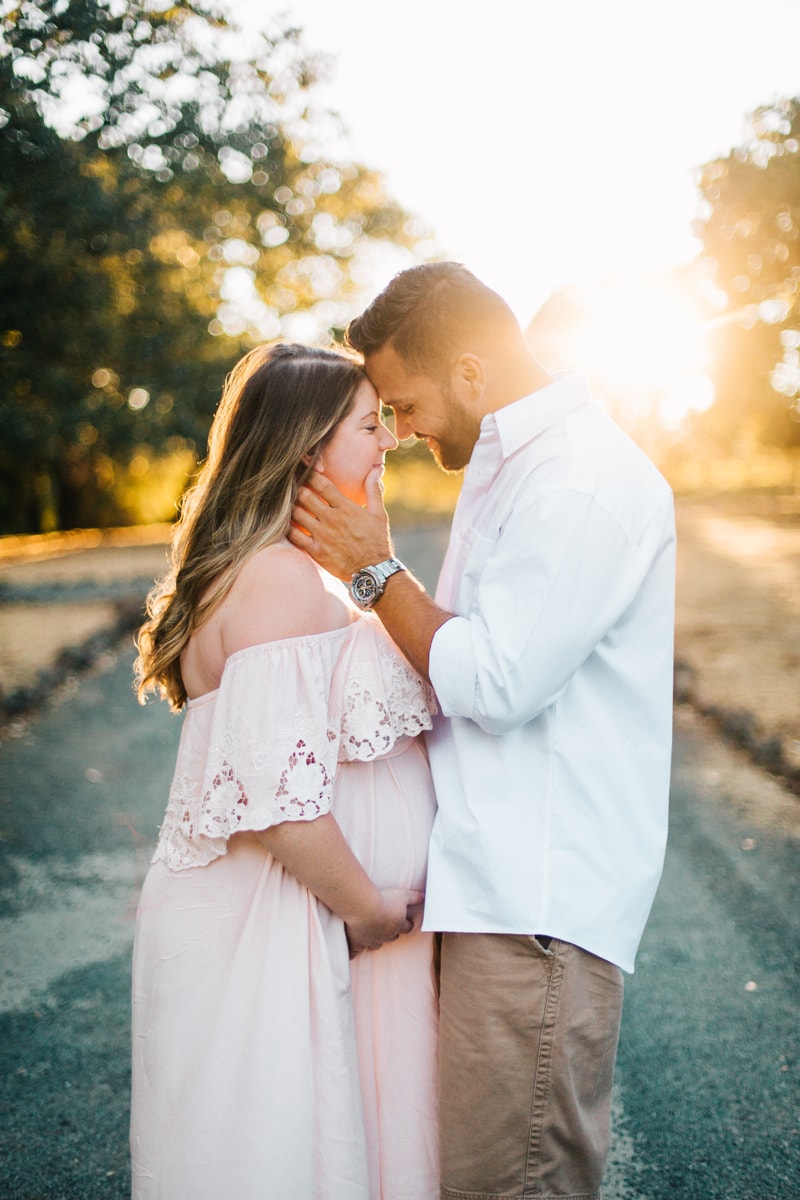 Maternity Photographer, couple resting their foreheads against each other with sunset in the background