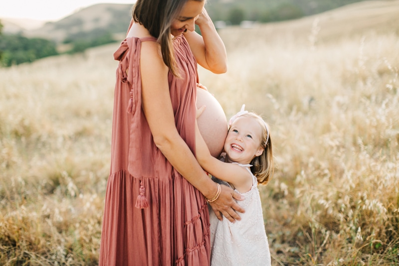 Maternity Photographer, little girl hugging mother's belly
