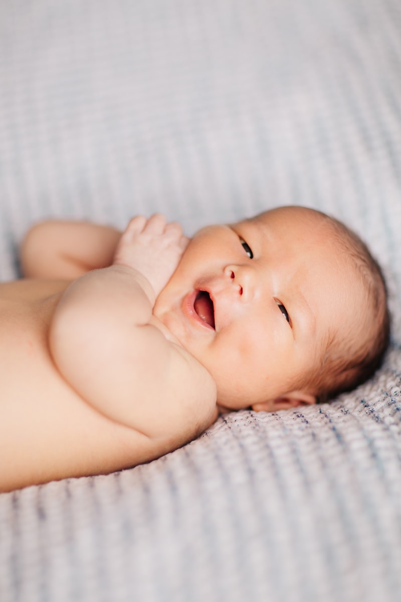 Newborn Photographer, baby opening its mouth and looking at camera
