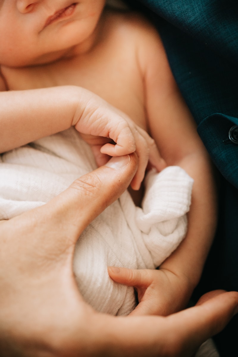 Newborn Photographer, close up shot of baby holding mother's finger