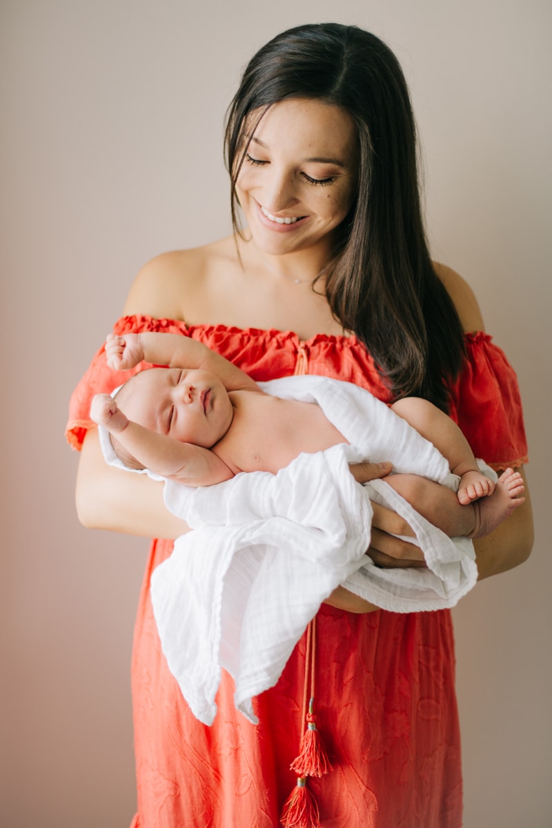 Newborn Photographer, mother holding baby while it stretches