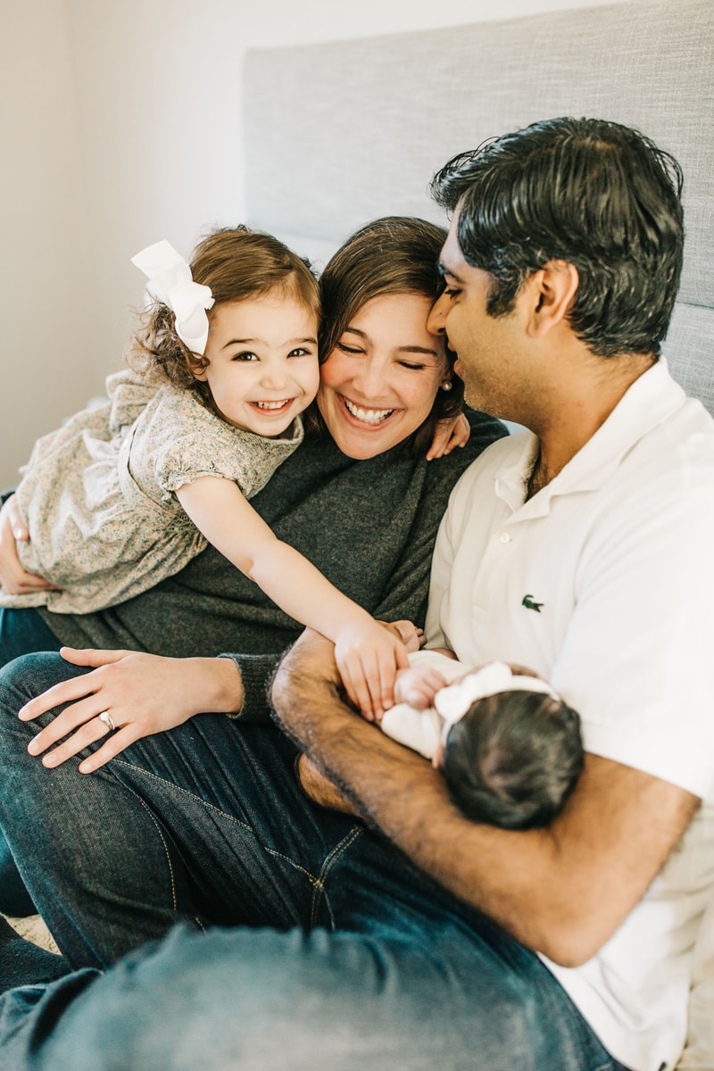 Newborn Photographer, family of 4 sitting together in bed