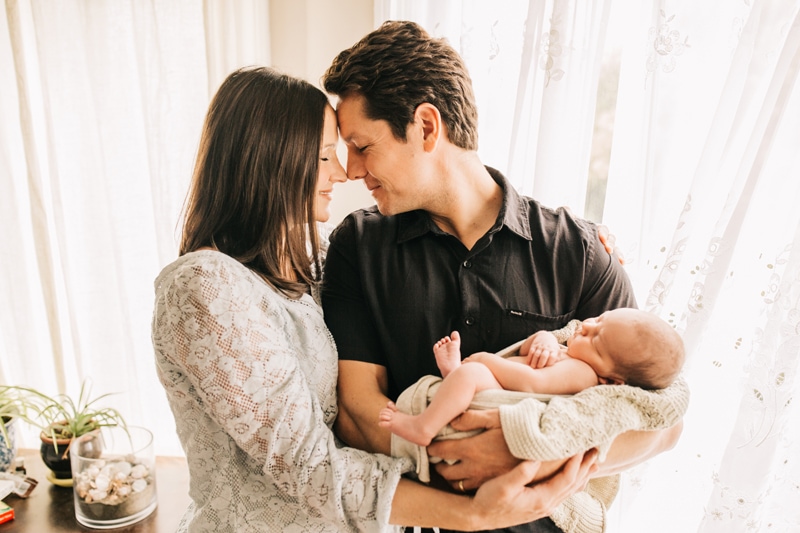 Newborn Photographer, mother and father standing together holding newborn baby