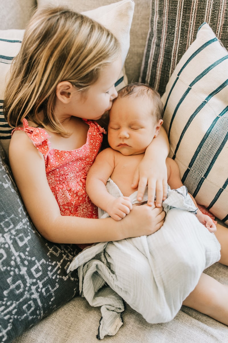 Newborn Photographer, little sister kissing baby on the head