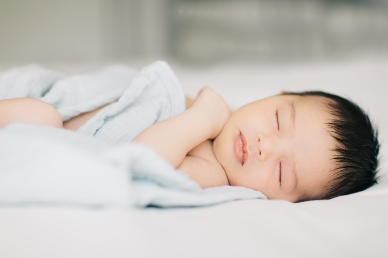 Newborn Photographer, baby sleeping with its head turned toward camera